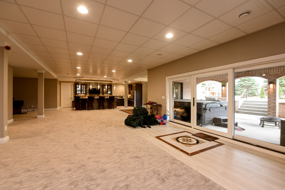 Photo of an expansive contemporary walk-out basement in Chicago with beige walls, carpet and beige floor.