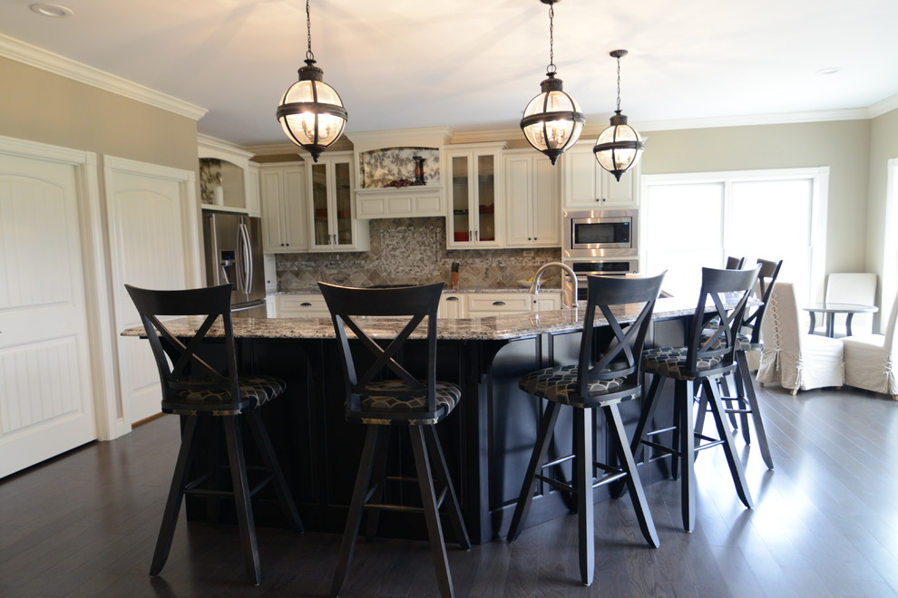 Eat-in kitchen - huge transitional l-shaped medium tone wood floor eat-in kitchen idea in Chicago with a farmhouse sink, raised-panel cabinets, white cabinets, granite countertops, gray backsplash, glass tile backsplash, stainless steel appliances and an island