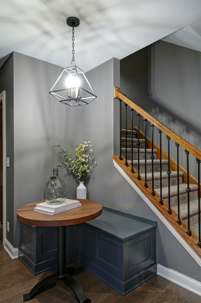 Large transitional underground medium tone wood floor and brown floor basement photo in Columbus with gray walls, a standard fireplace and a stone fireplace