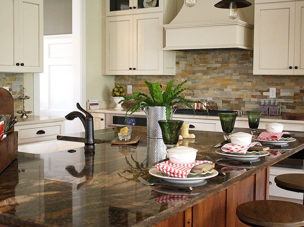 Inspiration for a transitional u-shaped medium tone wood floor open concept kitchen remodel in Richmond with a farmhouse sink, recessed-panel cabinets, beige cabinets, granite countertops, multicolored backsplash, stone tile backsplash, stainless steel appliances and an island