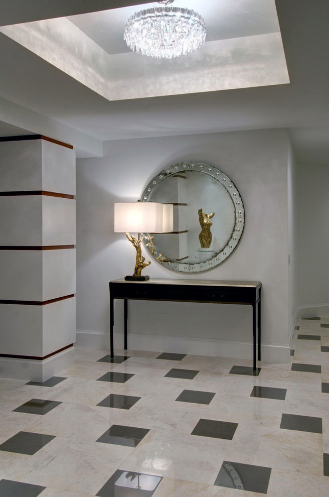 This is an example of a contemporary foyer in Miami with white walls and marble floors.