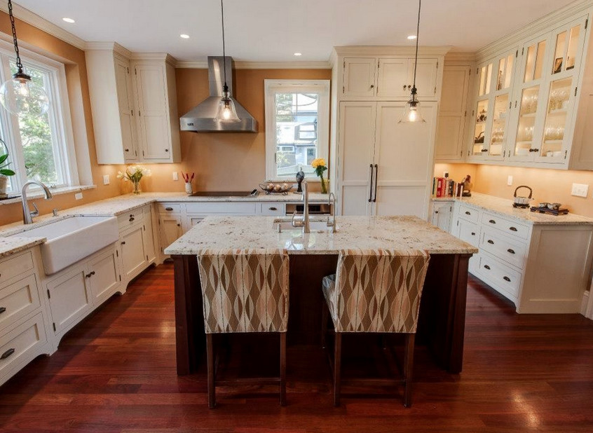 Open concept kitchen - mid-sized transitional u-shaped dark wood floor and brown floor open concept kitchen idea in Boston with a farmhouse sink, beaded inset cabinets, white cabinets, granite countertops, stainless steel appliances and an island