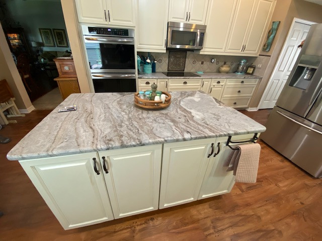 Inspiration for a large galley eat-in kitchen remodel with raised-panel cabinets, beige cabinets and an island