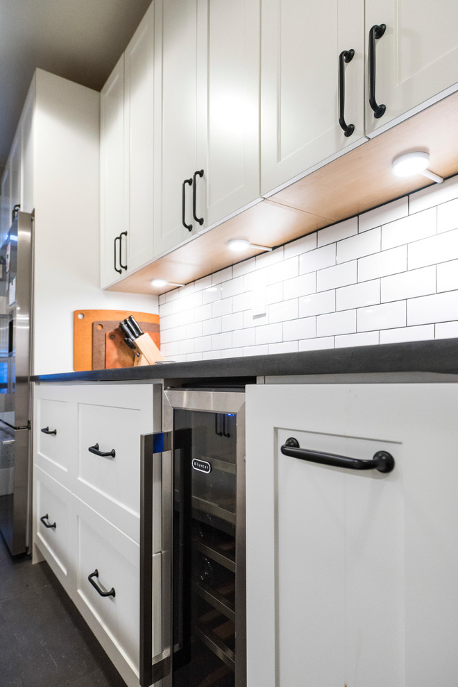 Inspiration for a small modern galley separate kitchen in New York with an undermount sink, shaker cabinets, white cabinets, white splashback, subway tile splashback, stainless steel appliances, vinyl floors and no island.