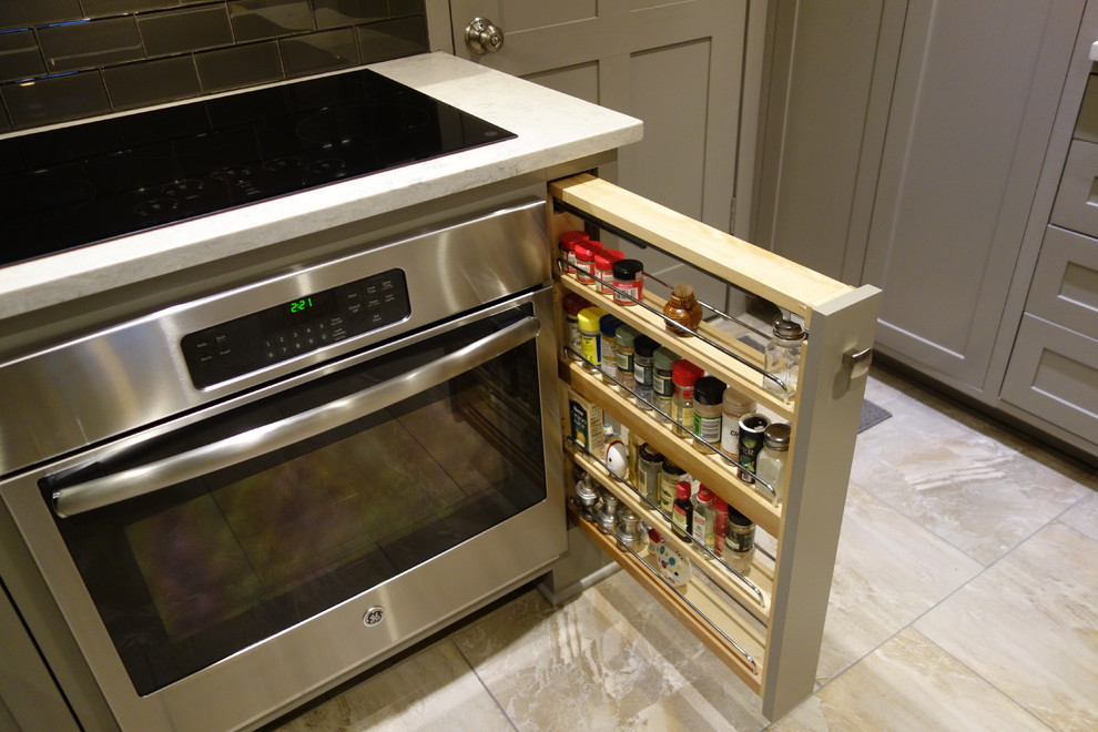 Example of a small transitional u-shaped ceramic tile home design design with an undermount sink, shaker cabinets, gray cabinets, quartz countertops, gray backsplash, glass tile backsplash, stainless steel appliances and a peninsula