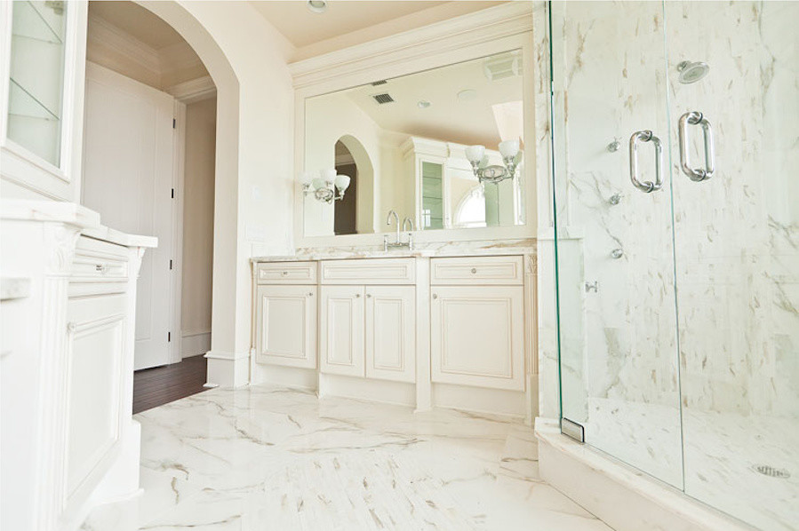 Inspiration for a traditional master bathroom in Miami with beaded inset cabinets, white cabinets, a corner shower, gray tile, white tile, stone tile, white walls, marble floors, an undermount sink, marble benchtops, white floor and a hinged shower door.