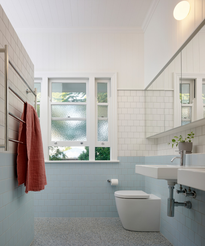 Design ideas for a mid-sized contemporary master bathroom in Brisbane with an open shower, blue tile, white walls, a wall-mount sink, tile benchtops, grey floor, a hinged shower door, white benchtops and a double vanity.