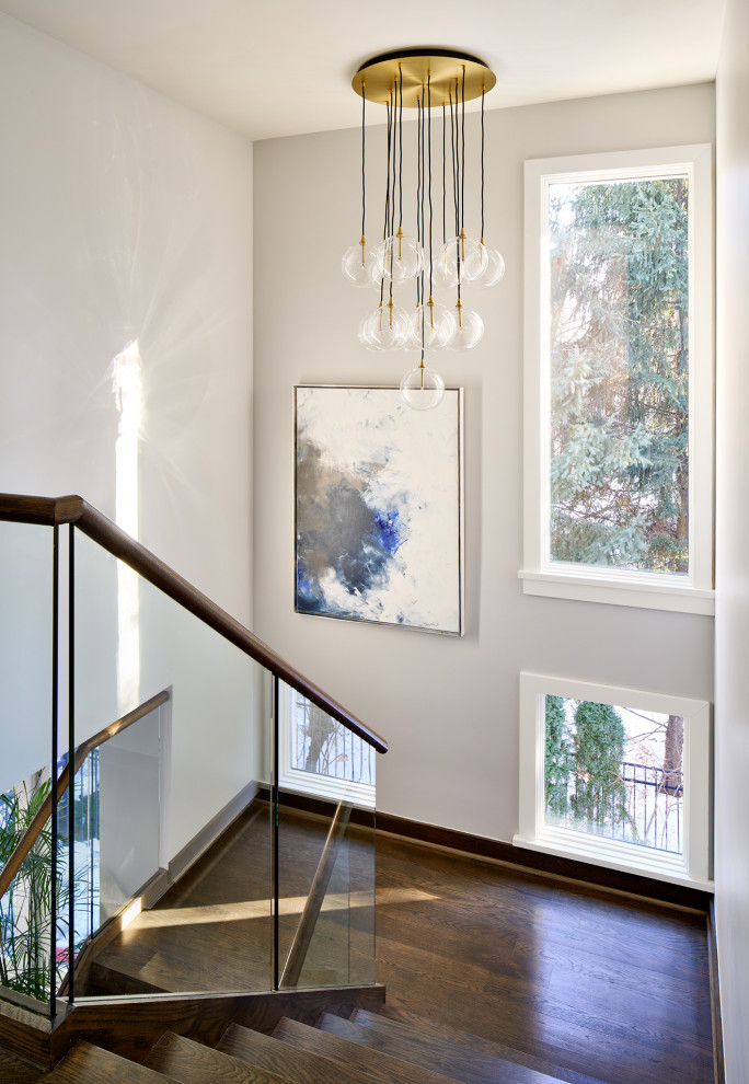 Example of a huge transitional wooden l-shaped glass railing and open staircase design in Chicago