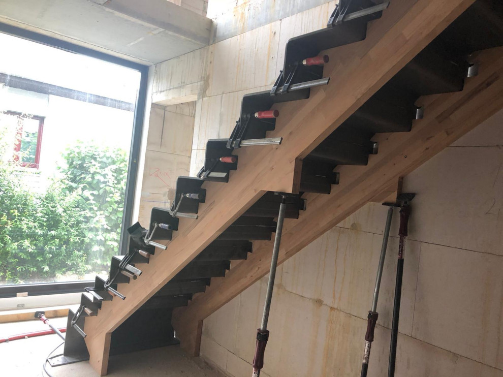 Imagen de escalera recta urbana con escalones de metal, contrahuellas de metal y barandilla de metal