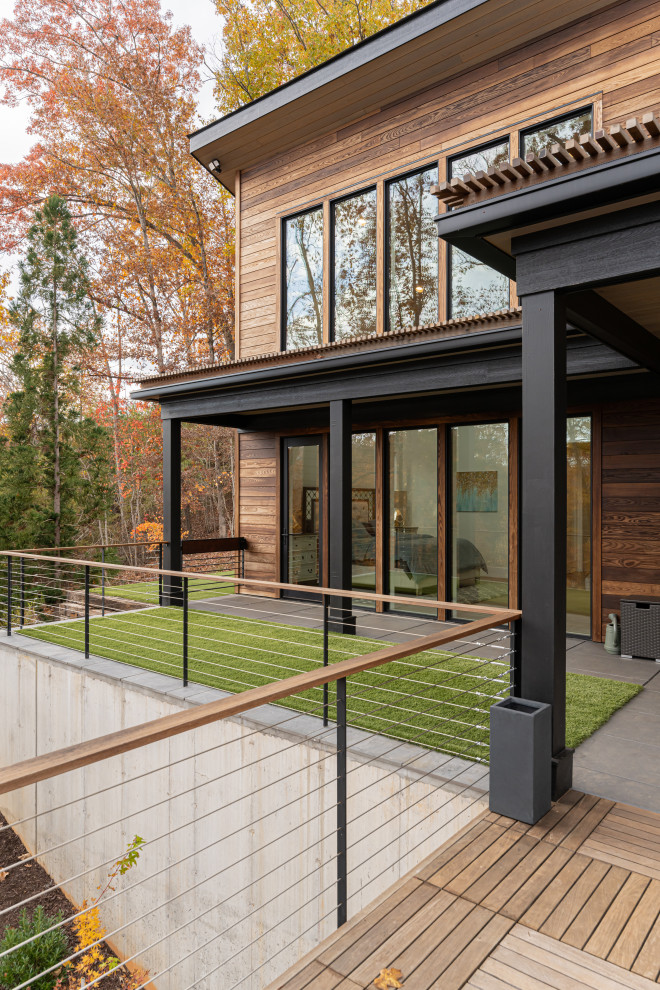 Idée de décoration pour une petite terrasse arrière et au premier étage minimaliste avec une extension de toiture et un garde-corps en câble.