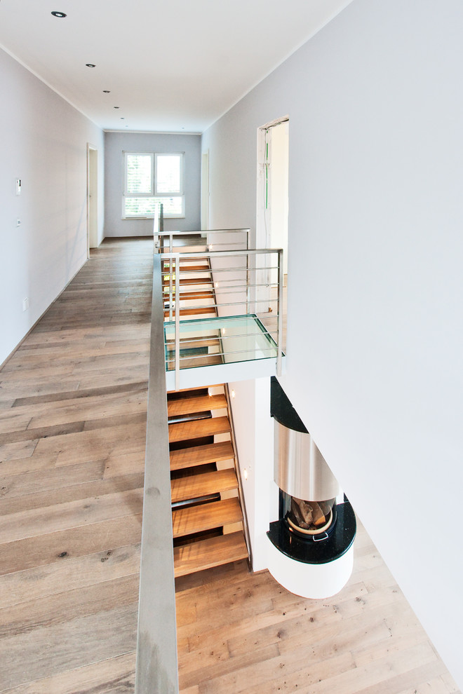 Large contemporary hallway in Frankfurt with white walls and dark hardwood floors.