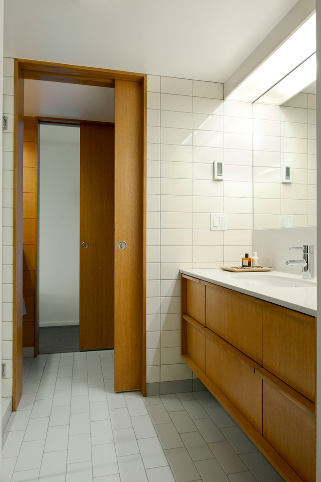 Photo of a midcentury bathroom in Seattle with medium wood cabinets and white tile.