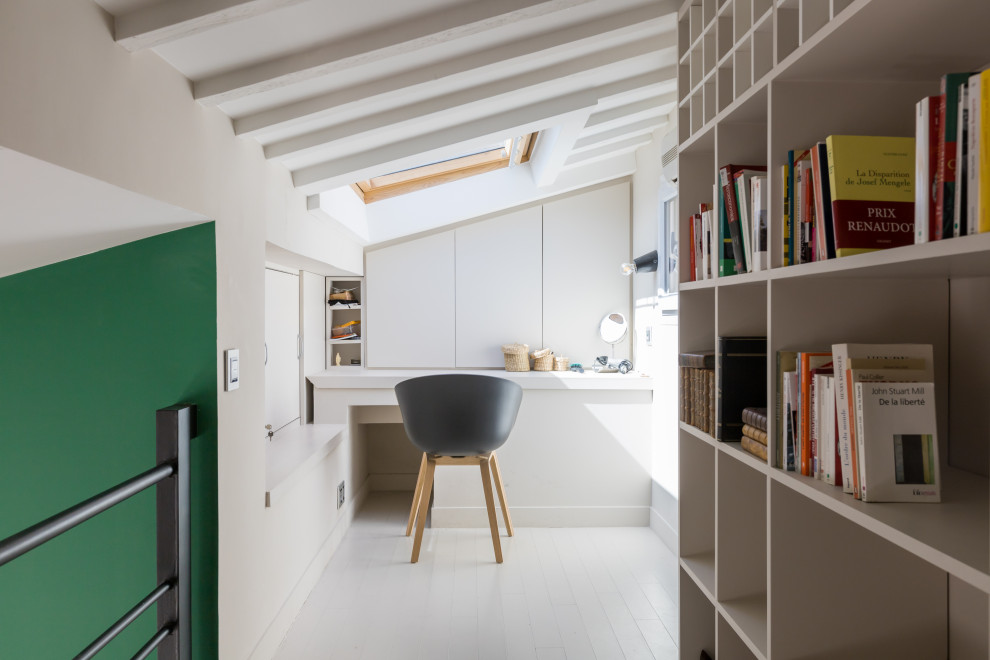 Kleines Stilmix Arbeitszimmer mit Arbeitsplatz, weißer Wandfarbe, gebeiztem Holzboden, Einbau-Schreibtisch, weißem Boden und freigelegten Dachbalken in Paris