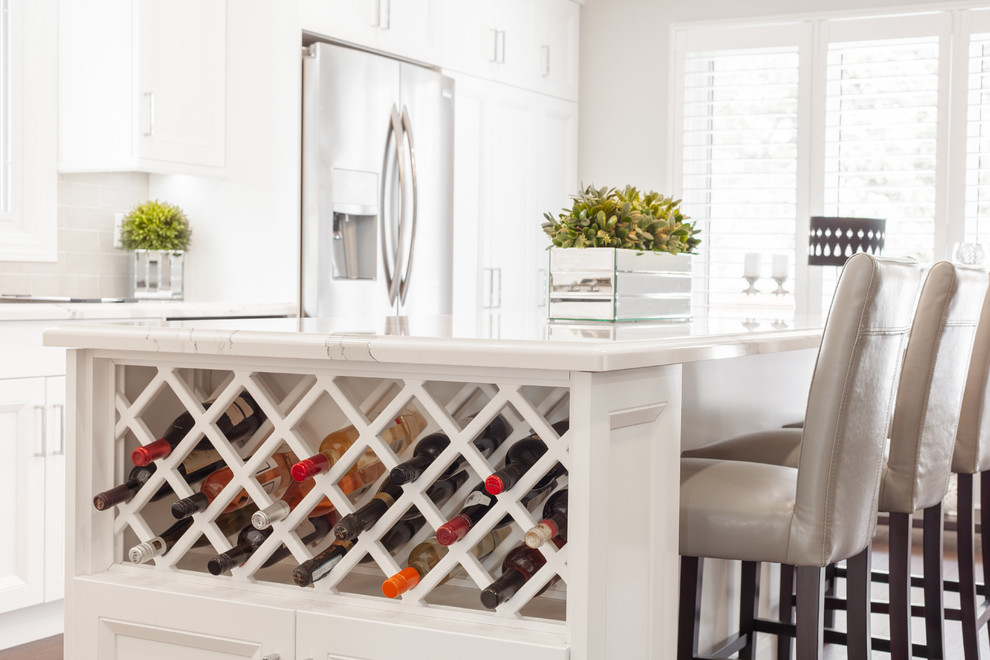 Inspiration for a large transitional l-shaped medium tone wood floor and brown floor enclosed kitchen remodel with an undermount sink, recessed-panel cabinets, white cabinets, quartz countertops, gray backsplash, ceramic backsplash, stainless steel appliances, an island and white countertops