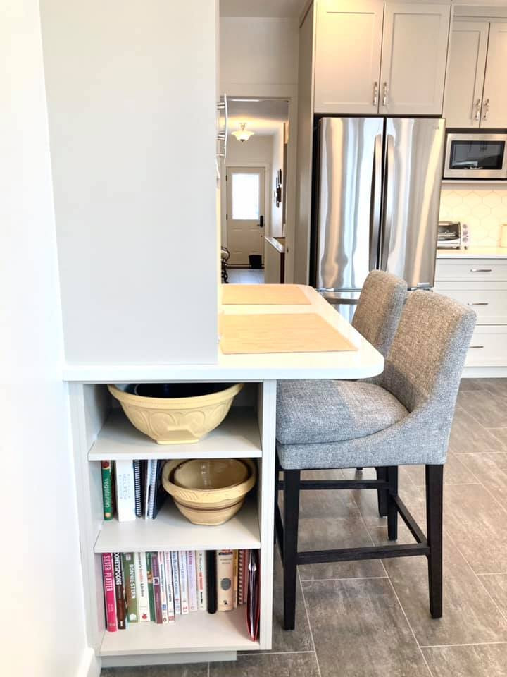 Example of a mid-sized transitional u-shaped vinyl floor and gray floor enclosed kitchen design with an undermount sink, shaker cabinets, beige cabinets, quartz countertops, white backsplash, ceramic backsplash, stainless steel appliances and white countertops