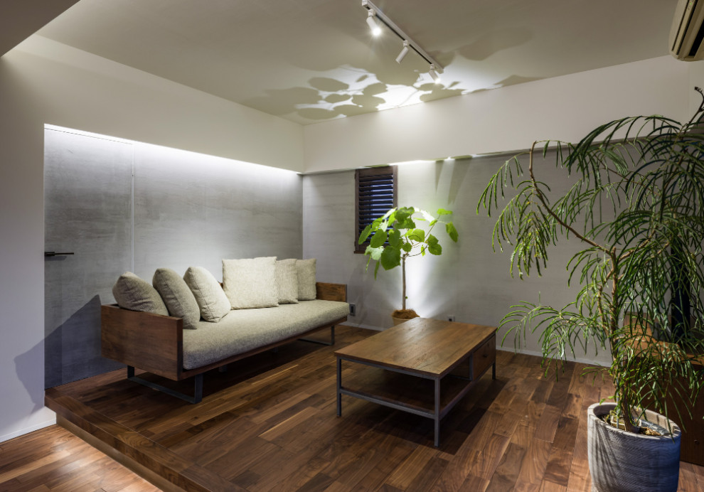 Свежая идея для дизайна: гостиная комната в восточном стиле с серыми стенами, темным паркетным полом и коричневым полом - отличное фото интерьера