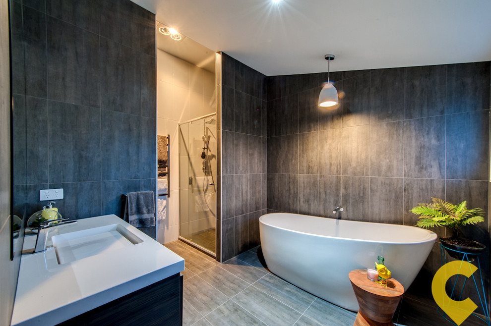 This is an example of a large contemporary master bathroom in Brisbane with a freestanding tub, a corner shower, gray tile, ceramic tile, grey walls, ceramic floors and a wall-mount sink.