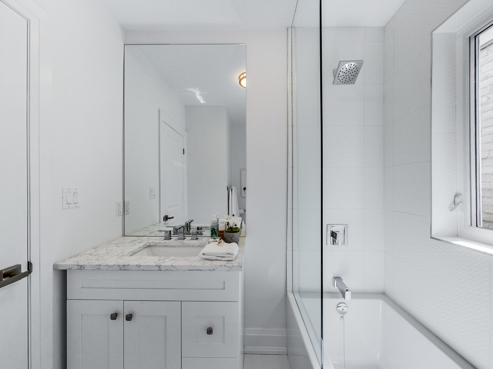 Mid-sized modern kids bathroom in Toronto with shaker cabinets, white cabinets, an alcove tub, a shower/bathtub combo, white tile, ceramic tile, white walls, ceramic floors, an undermount sink, engineered quartz benchtops, white floor and an open shower.