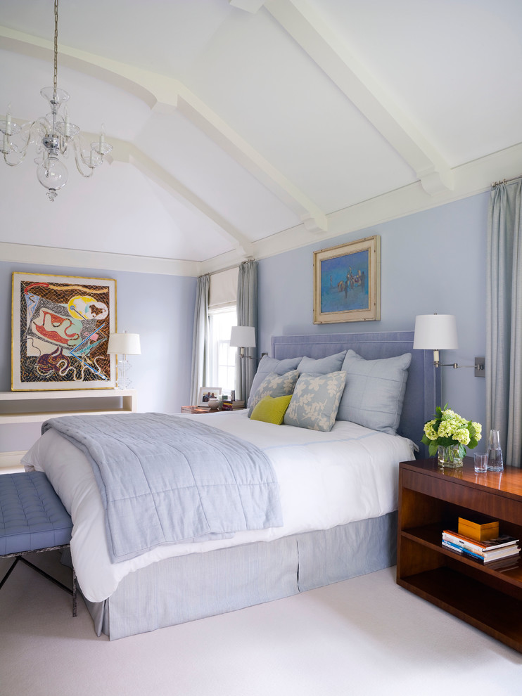 This is an example of a transitional master bedroom in New York with blue walls and carpet.