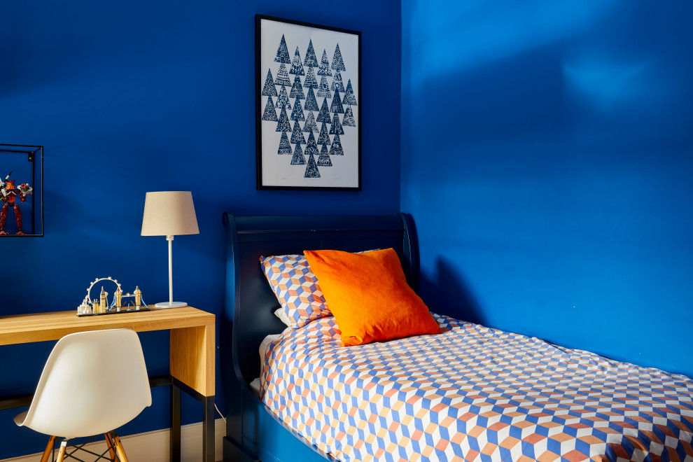 Design ideas for a small contemporary kids' bedroom for kids 4-10 years old and boys in Surrey with blue walls, light hardwood floors and brown floor.