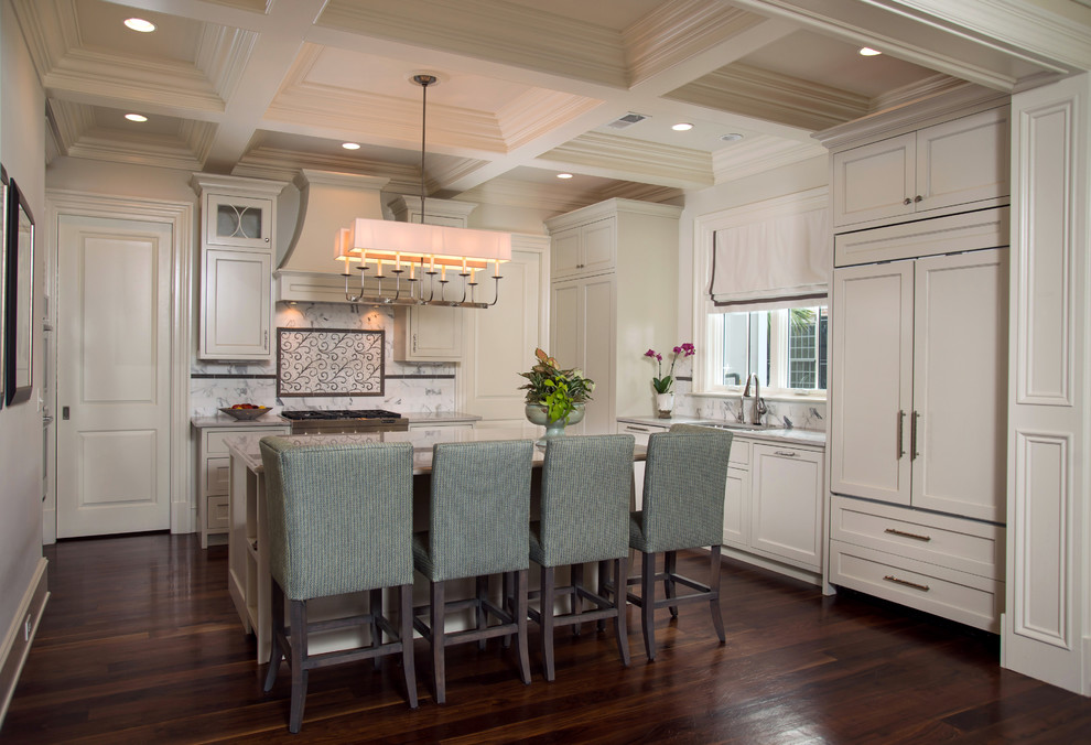 Inspiration for a mid-sized transitional l-shaped kitchen pantry in Charleston with recessed-panel cabinets, white splashback, marble splashback, dark hardwood floors, with island, a drop-in sink, grey cabinets, granite benchtops, panelled appliances and brown floor.