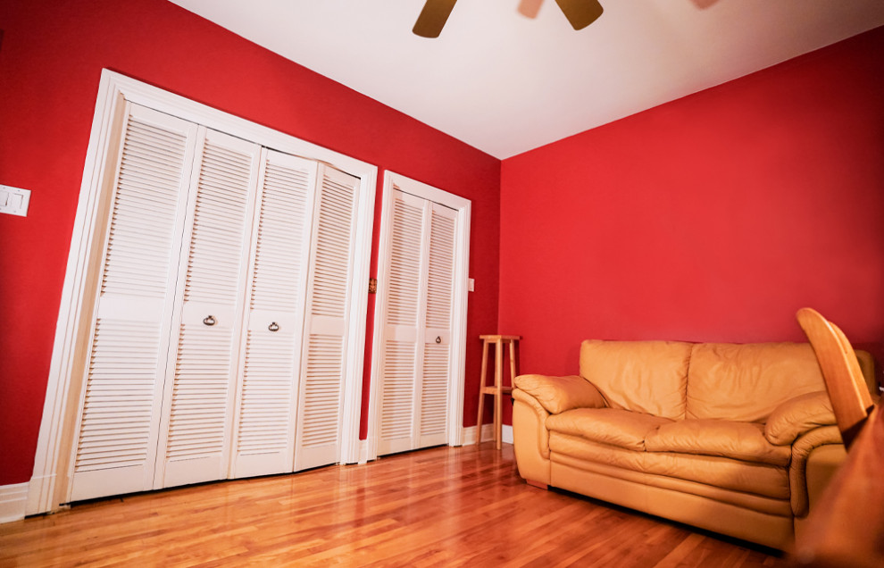 Esempio di un soggiorno minimalista di medie dimensioni e chiuso con pareti rosse e parquet chiaro