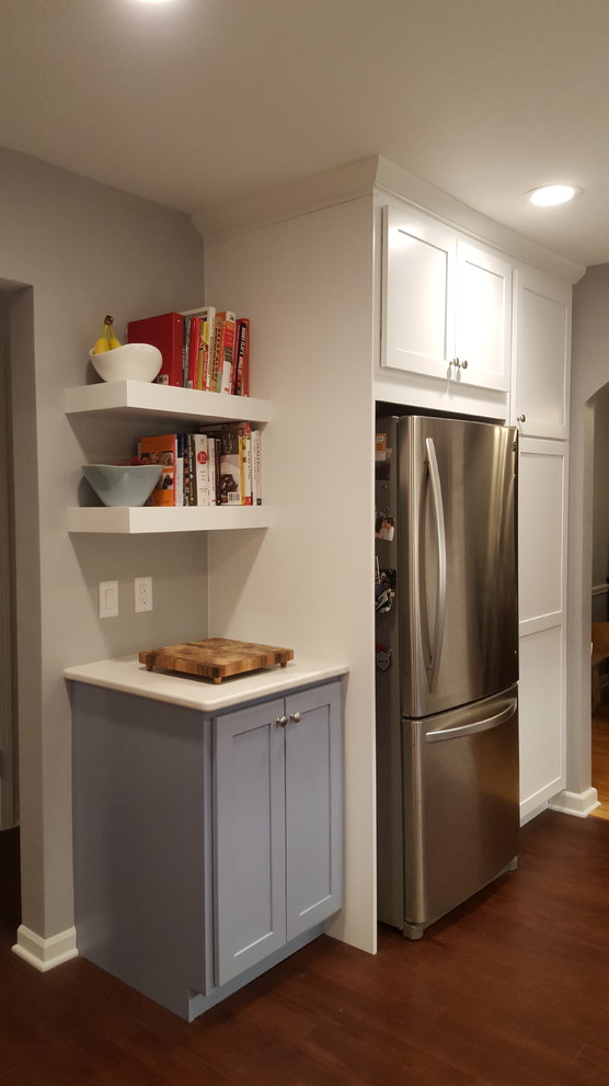 Inspiration for a mid-sized transitional u-shaped vinyl floor enclosed kitchen remodel with a farmhouse sink, recessed-panel cabinets, blue cabinets, quartz countertops, stainless steel appliances and a peninsula