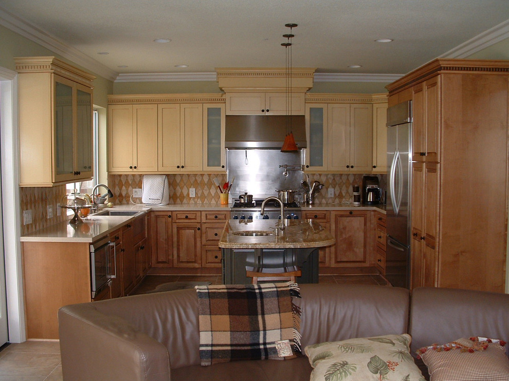 Inspiration for a mid-sized transitional u-shaped travertine floor eat-in kitchen remodel in Orange County with a farmhouse sink, shaker cabinets, yellow cabinets, quartz countertops, multicolored backsplash, stone tile backsplash, stainless steel appliances and an island