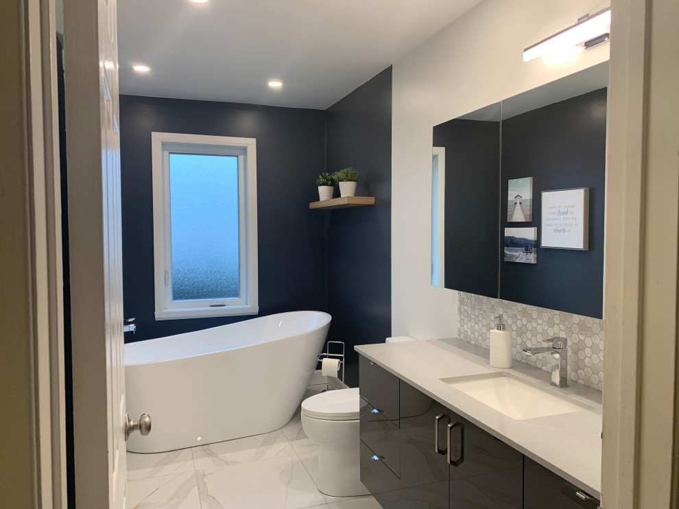 Inspiration for a medium sized modern ensuite bathroom in Montreal with flat-panel cabinets, blue cabinets, a freestanding bath, a double shower, a one-piece toilet, white tiles, porcelain tiles, blue walls, porcelain flooring, a submerged sink, quartz worktops, white floors, an open shower, grey worktops, a wall niche, a single sink and a floating vanity unit.