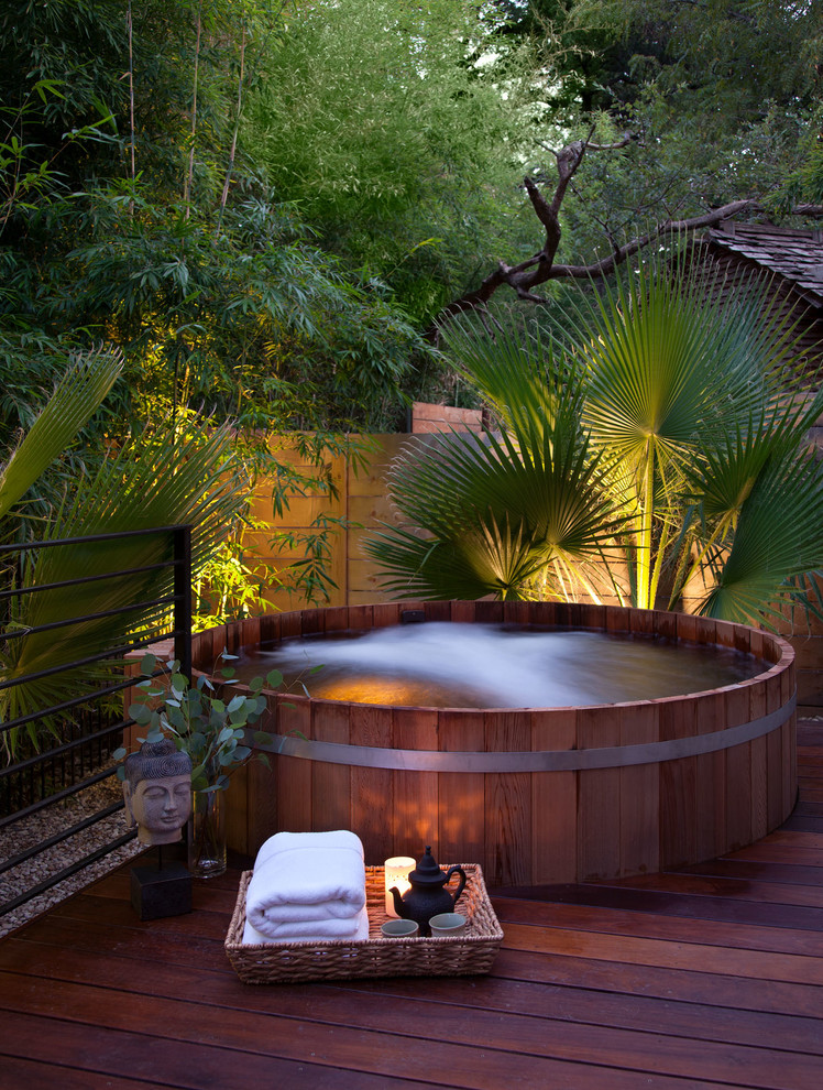 Photo of a modern backyard deck in Austin with a water feature.