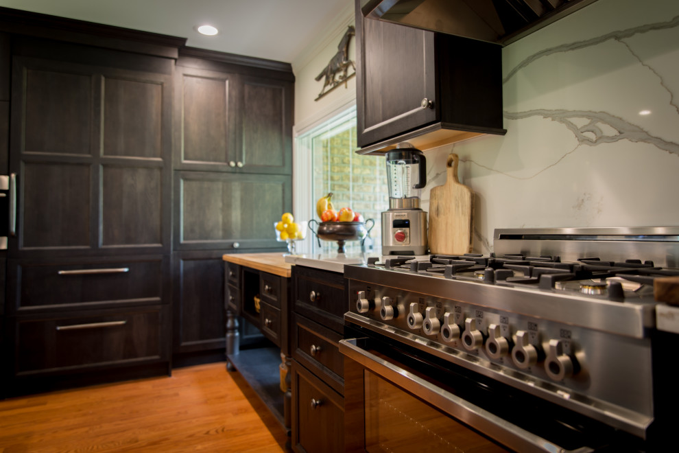 Example of a large mountain style l-shaped light wood floor and brown floor eat-in kitchen design with an undermount sink, recessed-panel cabinets, dark wood cabinets, quartz countertops, white backsplash, stainless steel appliances, an island, white countertops and quartz backsplash