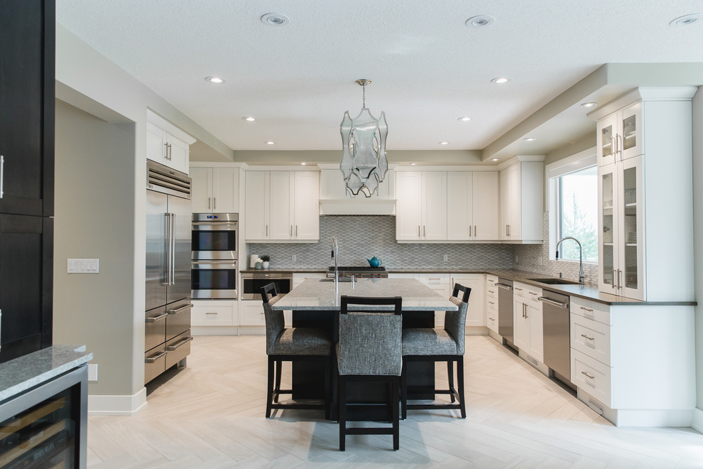 Design ideas for a large contemporary u-shaped eat-in kitchen in Edmonton with an undermount sink, shaker cabinets, white cabinets, quartz benchtops, white splashback, porcelain splashback, stainless steel appliances, porcelain floors, with island and grey floor.