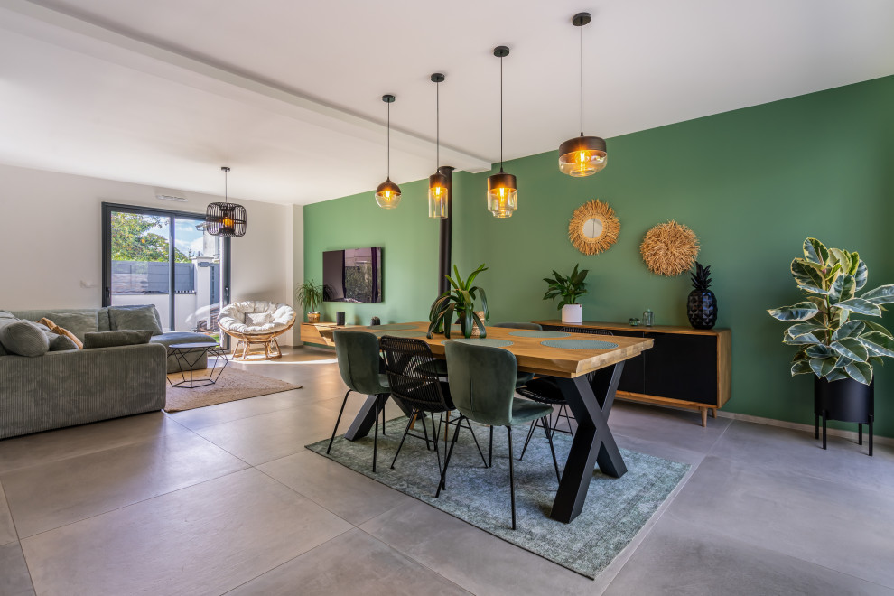 Inspiration pour une salle à manger ouverte sur le salon design de taille moyenne avec un mur vert, un sol en carrelage de céramique, un poêle à bois, un sol gris et un plafond à caissons.