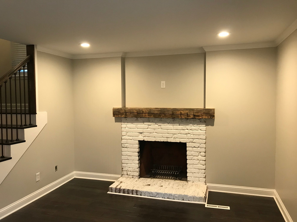 Design ideas for a transitional living room in Birmingham with beige walls, dark hardwood floors, a standard fireplace, a brick fireplace surround and brown floor.