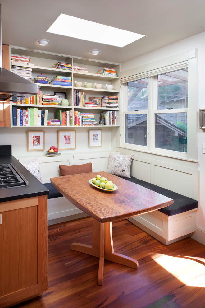 This is an example of a traditional eat-in kitchen in Portland with white cabinets and medium hardwood floors.