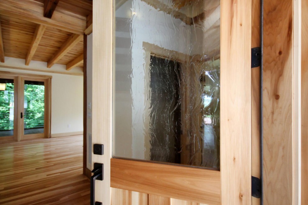 Front door - mid-sized light wood floor front door idea with white walls and a light wood front door