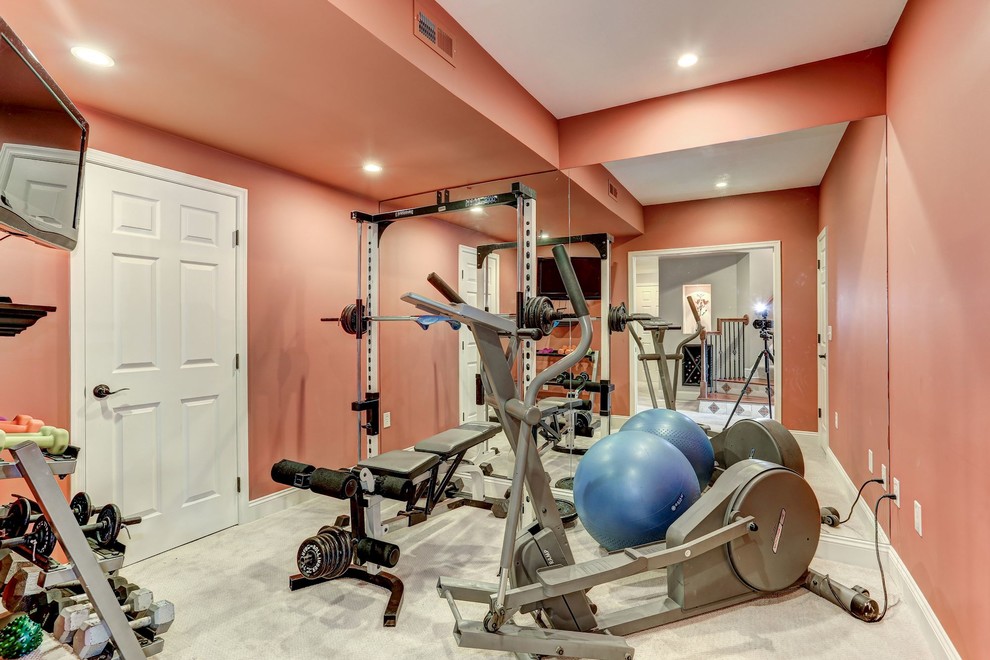 This is an example of a mid-sized contemporary home weight room in DC Metro with orange walls, carpet and white floor.