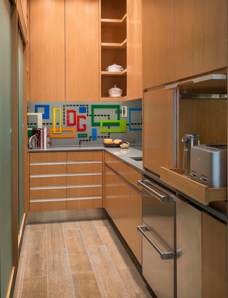 This is an example of an expansive midcentury u-shaped kitchen pantry in Austin with an undermount sink, flat-panel cabinets, medium wood cabinets, solid surface benchtops, grey splashback, stainless steel appliances, porcelain floors and no island.