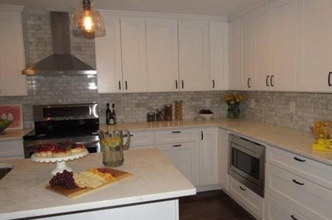 Example of a trendy l-shaped dark wood floor eat-in kitchen design in Boston with a double-bowl sink, shaker cabinets, white cabinets, marble countertops, multicolored backsplash, stone tile backsplash, stainless steel appliances and an island
