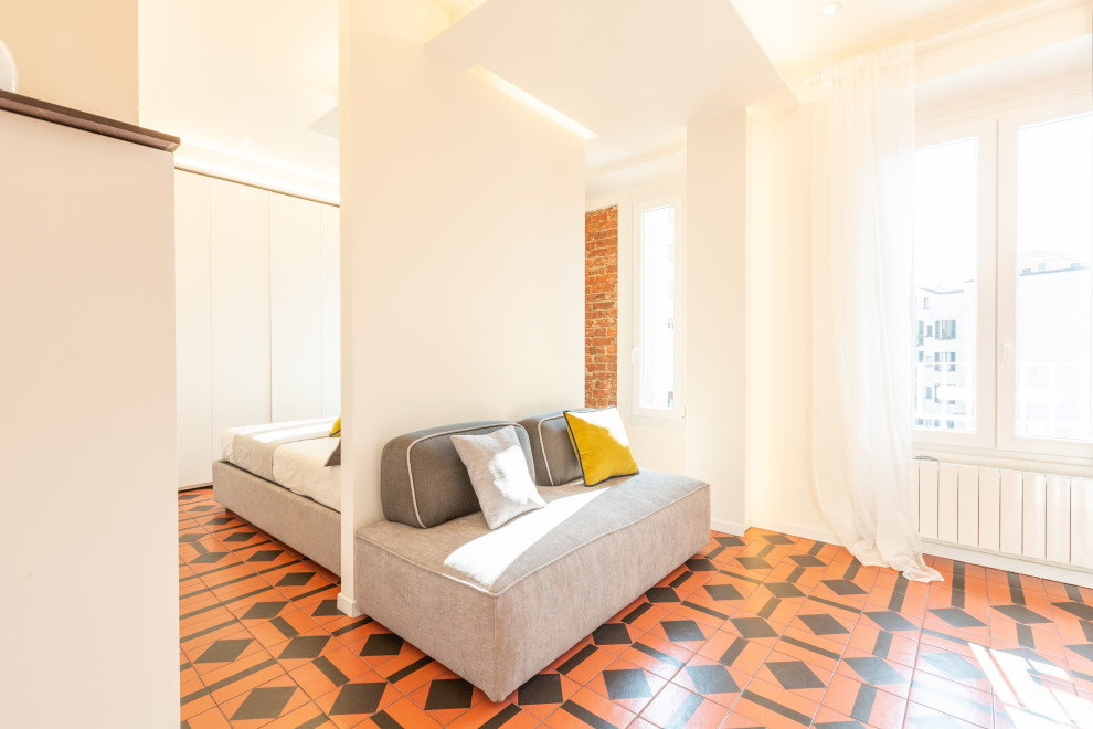 Living room - small 1960s open concept ceramic tile, tray ceiling and brick wall living room idea in Milan with beige walls