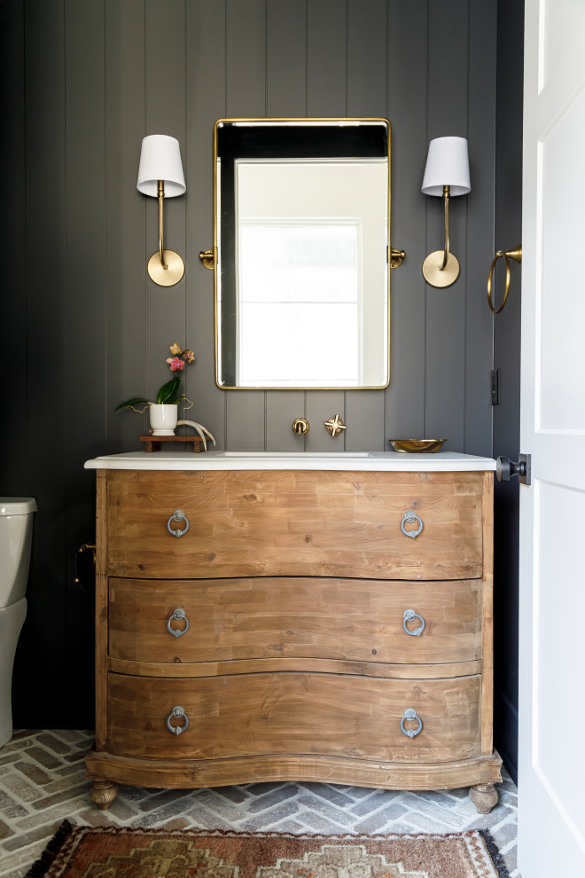 Small country powder room in Boise with medium wood cabinets, black walls, brick floors, an undermount sink, white benchtops and planked wall panelling.