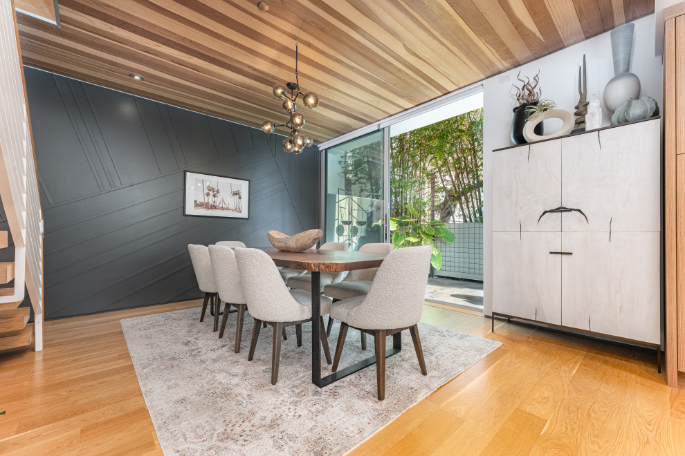 Cette image montre une salle à manger ouverte sur la cuisine design en bois de taille moyenne avec un mur gris, un sol en bois brun et un plafond en bois.