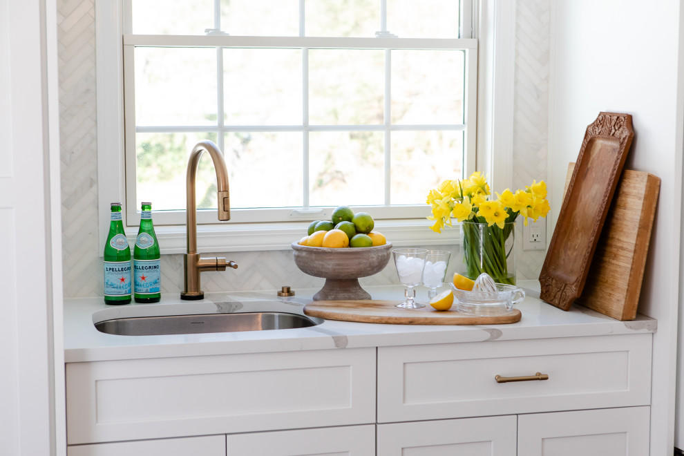 Open concept kitchen - large transitional l-shaped medium tone wood floor open concept kitchen idea with an undermount sink, shaker cabinets, white cabinets, quartz countertops, gray backsplash, marble backsplash, paneled appliances, an island and white countertops