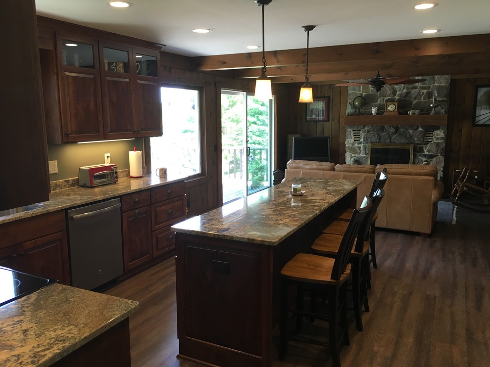 Open concept kitchen - large transitional u-shaped open concept kitchen idea with an undermount sink, raised-panel cabinets, dark wood cabinets, granite countertops, stainless steel appliances and an island