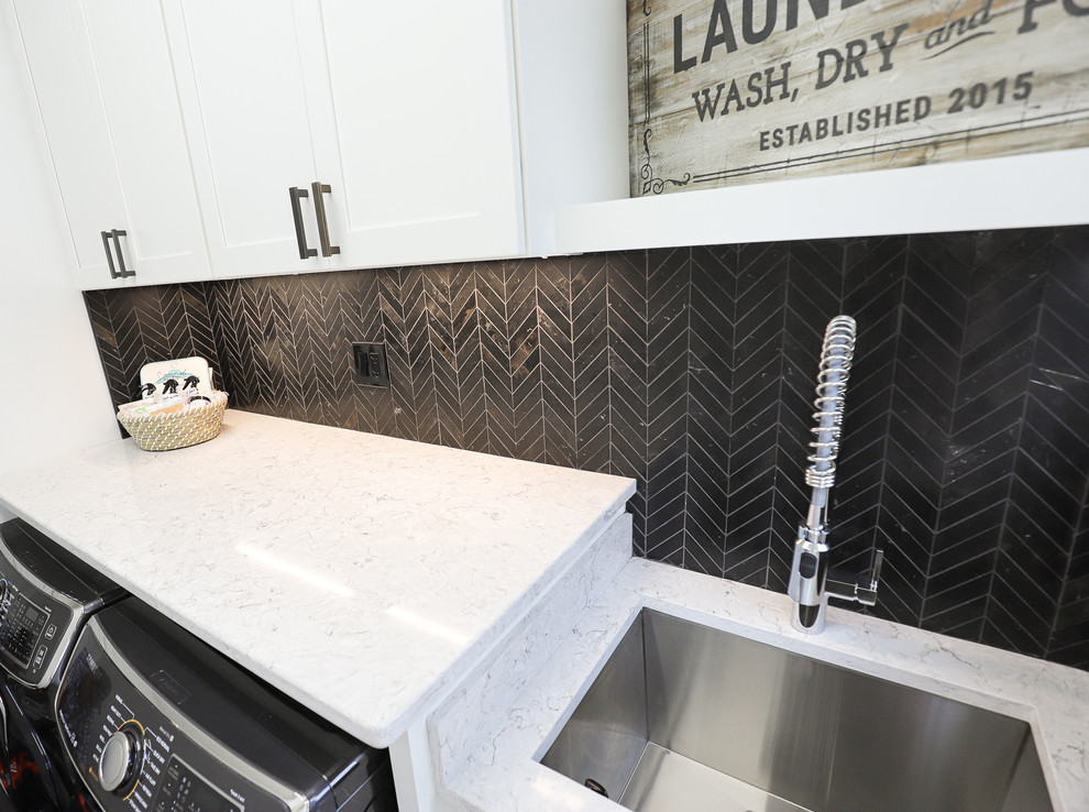 Photo of a small galley dedicated laundry room in Other with an undermount sink, shaker cabinets, white cabinets, quartz benchtops, white walls, ceramic floors, a side-by-side washer and dryer, black floor and multi-coloured benchtop.