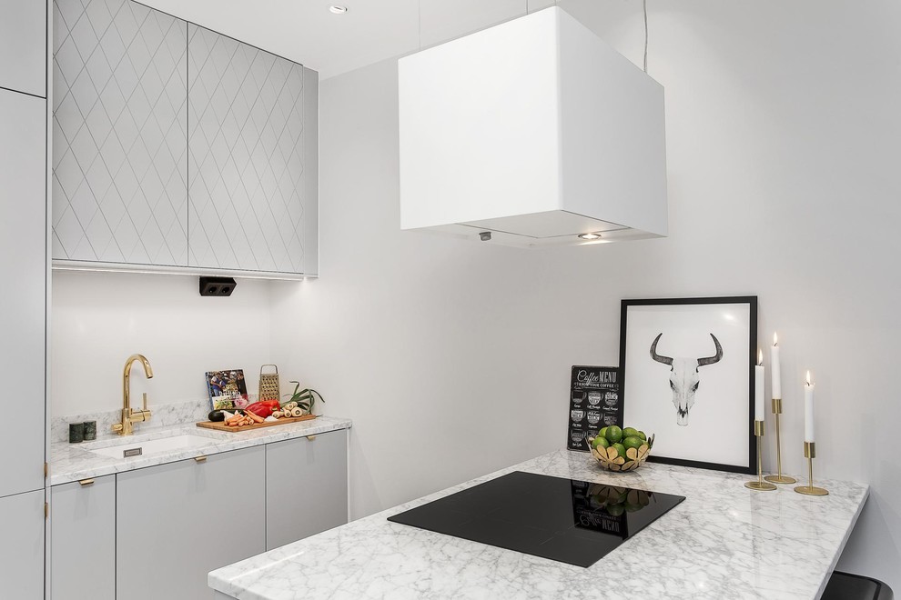 Inspiration for a small scandinavian galley open plan kitchen in Stockholm with an undermount sink, flat-panel cabinets, grey cabinets, a peninsula, marble benchtops, grey splashback, stone tile splashback, stainless steel appliances and light hardwood floors.