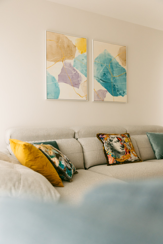 Detalle del sofá, cojines y cuadros