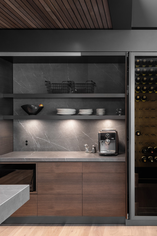 Photo of a mid-sized modern single-wall kitchen pantry in Los Angeles with a drop-in sink, flat-panel cabinets, brown cabinets, solid surface benchtops, black splashback, ceramic splashback, laminate floors, with island, beige floor and black benchtop.