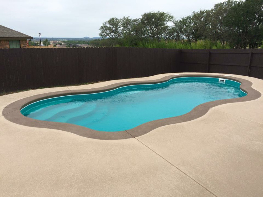 Large minimalist indoor concrete and custom-shaped indoor pool photo in Austin