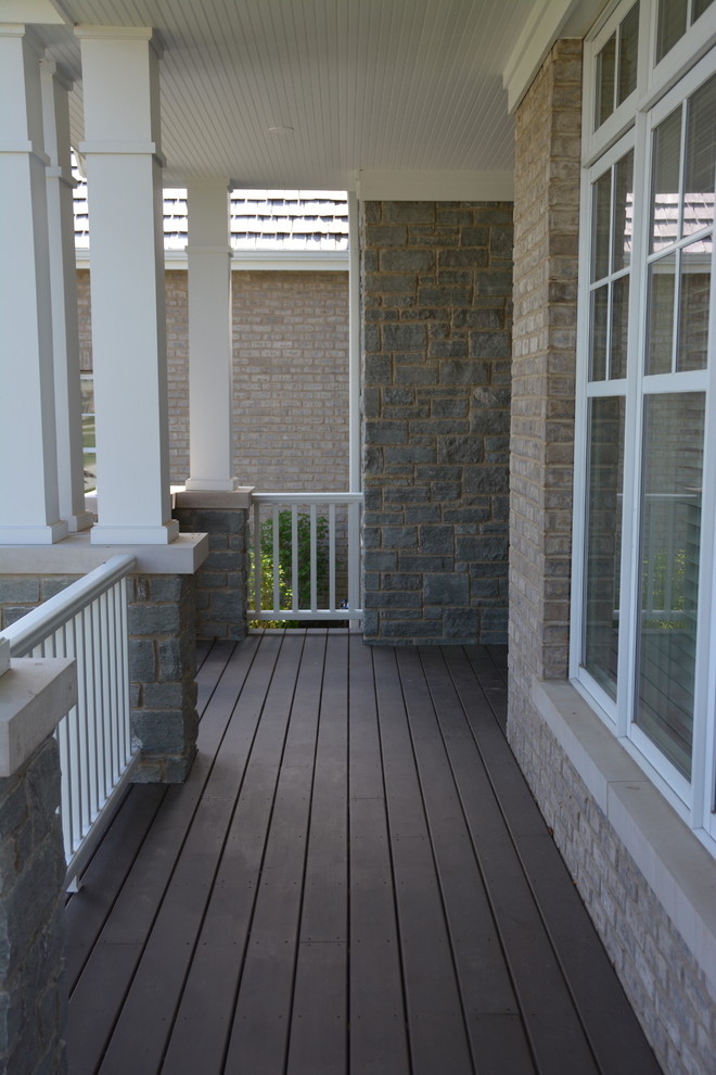 This is an example of a large arts and crafts front yard verandah in Chicago with decking and a roof extension.